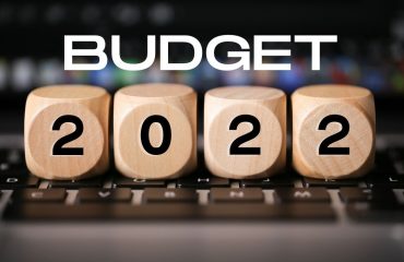 A keyboard with wooden blocks on top that spell Budget 2022