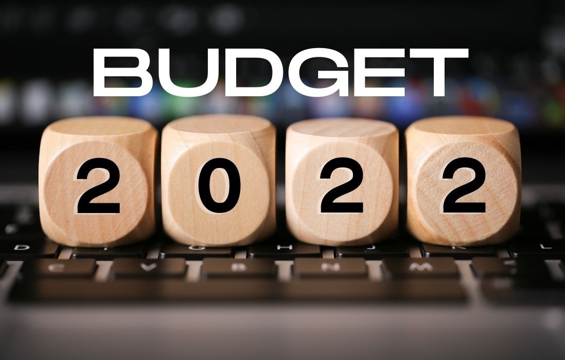 A keyboard with wooden blocks on top that spell Budget 2022