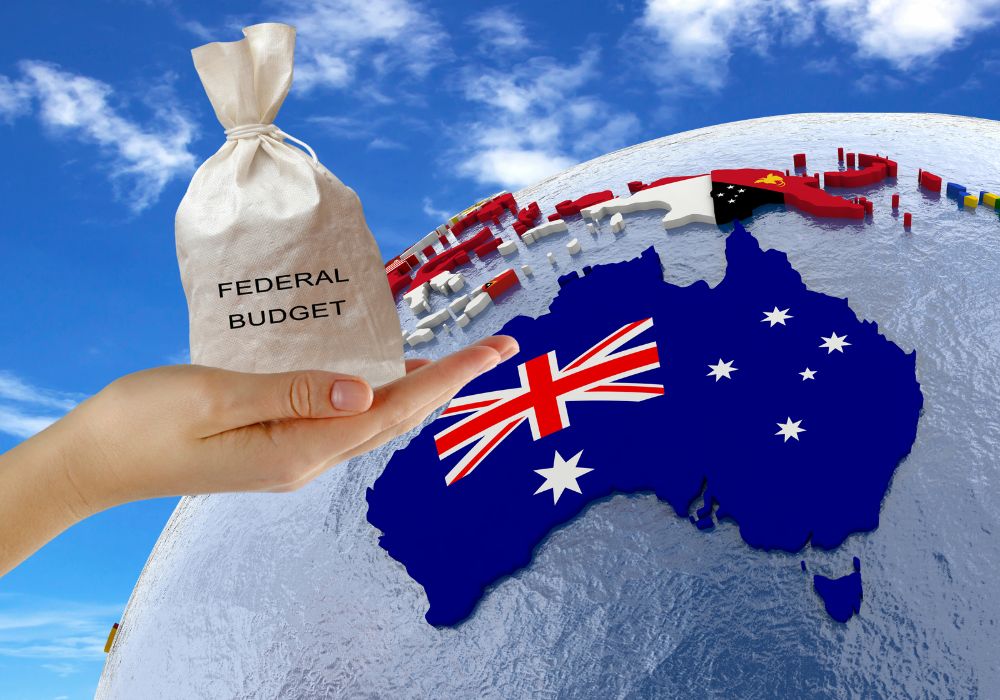 A person handing a bag of money labelled federal budget to a map of australia