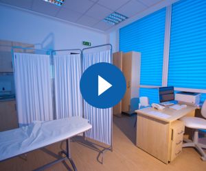 medical rooms with a desk and bed and privacy panels