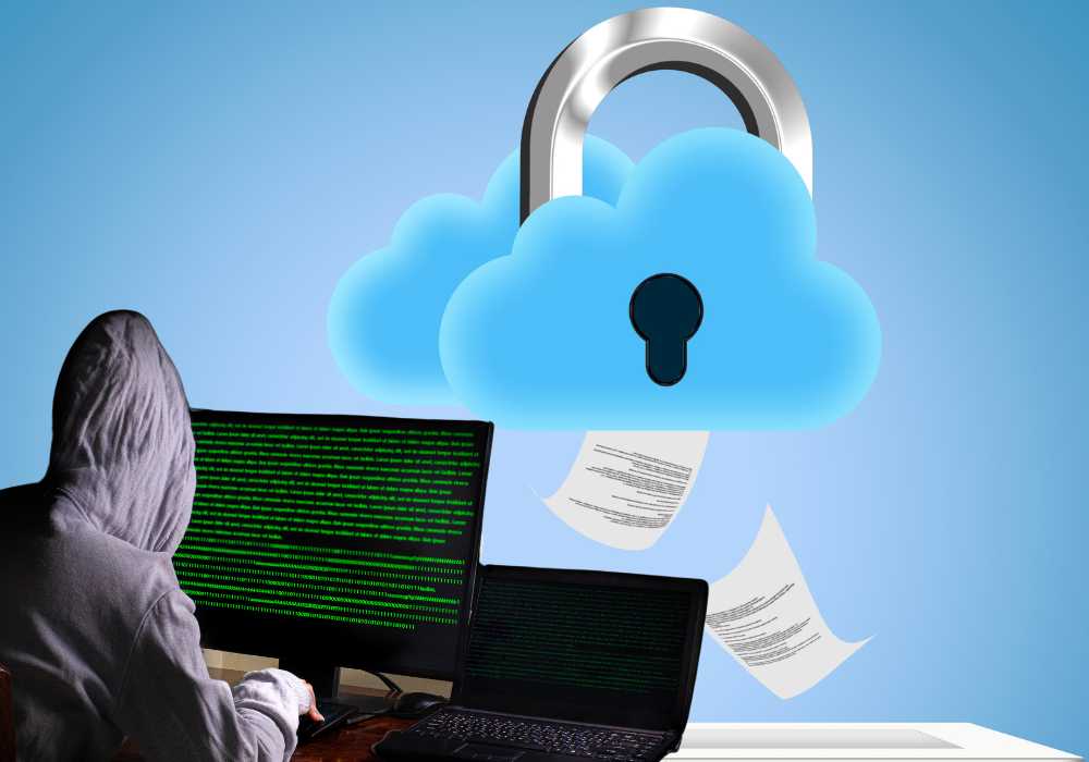 hacker sitting in front of two screens as someone's cloud documents float away